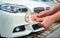 female hands with manicure holding a large amount of euro banknotes on the background of cars