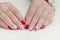 Female hands with manicure, red nail polish, drawing with cherries. White background