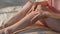 Female hands massaging legs soft skin closeup. Relaxed woman rubbing body cream