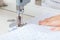 Female hands of a master tailor at work, a sewing machine needle