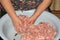 Female hands mixes a lot of ground beef in a metal pan in the kitchen. Cooking cutlets steaks. Homemade Minced meat in bowl for