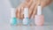 Female hands and nailpolish bottles, organic cosmetic product for french manicure, colourful pastel nail polish on