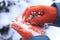 Female hands in orange gloves with stuck snow