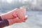 Female hands in pink mittens holding cup with hot tea or coffee. Close up