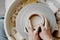 Female hands of potter forming clay product on potters wheel