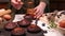 Female hands pour caramel filling into chocolate cupcake.