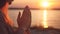 Female hands praying at beach at sunset