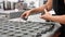 Female hands of professional confectioner preparing molds for baking tartlets at pastry shop.