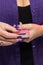 Female hands with a purple manicure hold a deck of play cards