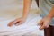 Female hands put a cover on the mattress to protect it from water and house dust mites