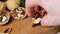 Female hands put peeled walnuts wooden board, close-up