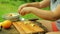 Female hands put pieces of apple in a bowl for alat on a picnic.