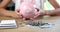 Female hands putting piggy bank on table in front of money closeup 4k movie slow motion