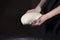 Female hands and raw dough close-up on a dark background