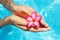 Female hands with red frangipani over blue ground