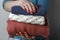 Female hands with a red manicure holding a stack of knitted woolen things, front view, close-up