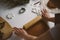 Female hands roll out raw ginger dough with a rolling pin on a white tabl