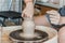 female hands sculpting clay on a Potter`s wheel. Concept of hobby and cretivity at home and in the Studio workshop