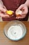 Female hands separate the egg white from the yolk over a bowl of wheat flour in the kitchen