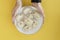 female hands serving delicious, fresh, homemade italian ravioli on a clay plate on a yellow background.