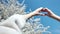 Female hands showing gesture heart love by hands white blossom sakura tree and sky in background POV shot