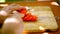 Female hands sliced tomato on a wooden board.