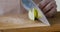 Female hands slicing fresh cucumber on cutting board