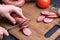 Female hands slicing homemade sausage on a cutting board