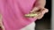 Female hands smear a green paste with a knife on the toast, close-up