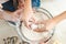 female hands split egg in bowl