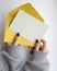 Female hands in a sweatshirt with manicure holding a white sheet and a yellow envelope on a white background. postcard layout