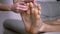 Female Hands Tickle Bare Male Feet, Toes, Outstretched on the Sofa. Close up