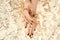 Female hands with trendy dark nail design with gold bracelets on golden background. Luxury concept. Festive backdrop for