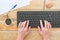 Female hands typing on the keyboard of a computer, on a vintage wood table