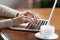 Female hands typing on keyboard, senior woman working on laptop