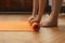 Female hands unrolling yoga mat in home on parquet floor