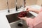 Female hands wash black grapes under the tap. Cook woman washes a bunch of black grapes under the water flowing from a