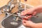 female hands washing cutlery under running water