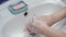Female Hands Washing in With Water, Soap and Foam Wash hands with soap warm water rubbing fingers washing frequently or sanitizer