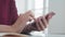 Female hands with a watch and a neat manicure hold the smartphone