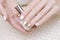 Female hands with white and gold nail design