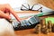 Female hands working on a calculator on wooden background