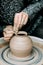 Female hands working on potter\\\'s wheel with clay pot