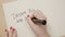 Female hands writing dream big and dare to fail exclamation point motivational quote on a white paper with a black marker -