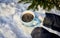 female handswith a blue mug of steaming coffee on the background of a winter forest