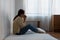 Female having depression sitting alone in bedroom corner. woman headache unhappy emotion. young anxiety despairing mental health
