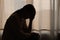 Female having depression sitting alone in bedroom dark corner. woman headache unhappy emotion. young anxiety despairing mental