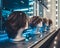 Female heads of mannequins in a row on a store window at night. Blue and white neon lights and glare on glass.