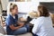 Female healthcare worker sitting on the sofa with a middle aged woman during a home health visit