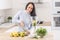 Female on a healthy diet chopping fruits to a blender for a raw food mixed snack